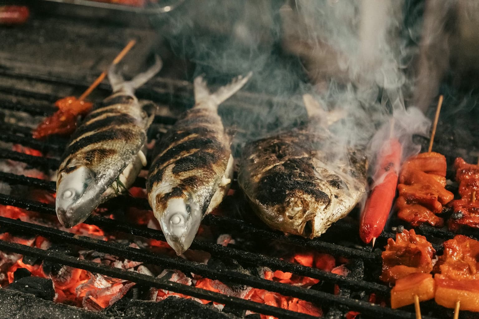 Whole fish grilling over glowing charcoal