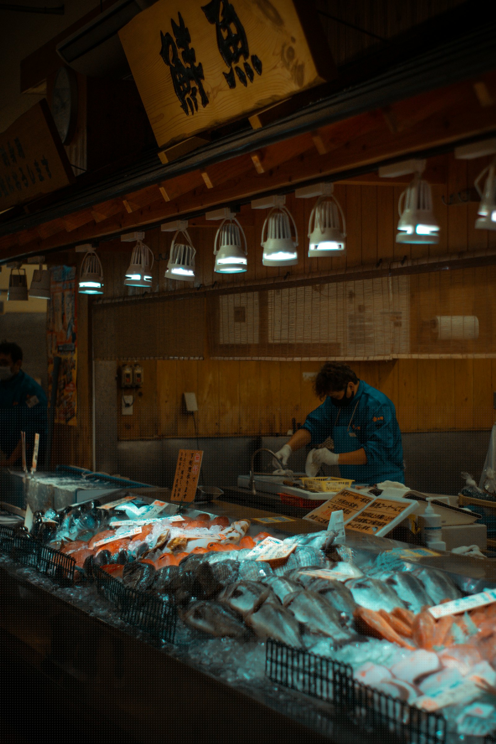A trader working behind a busy fish counter